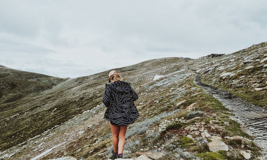Woman wearing the Elements Jacket in Topography on a beautiful hike outdoors