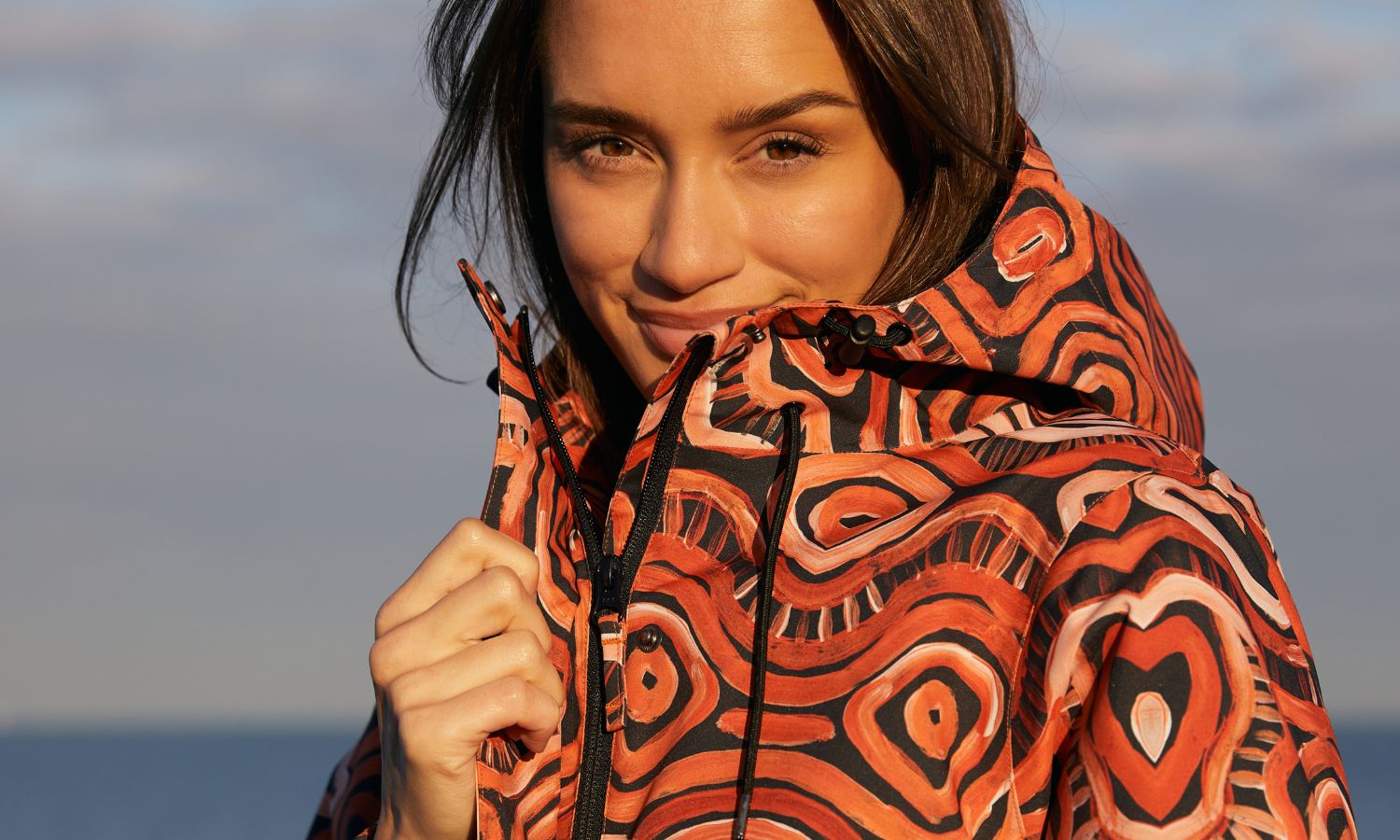 Model smiling while wearing the Refuge Jacket in the makukara ngurra prni